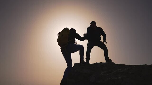 Silhouette teamwork peak people help each other. Team bond adventure people extend help. Climbing together people help support. Team effort ascent helping hand nature. Teamwork people offering help.