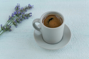 cup of coffee on table with purple lavender flowers