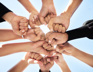 Below, hands and fist bump outdoor for teamwork, strength or unity for synergy. Group, huddle or people connected for power, solidarity or trust in community for protest, empowerment or organization
