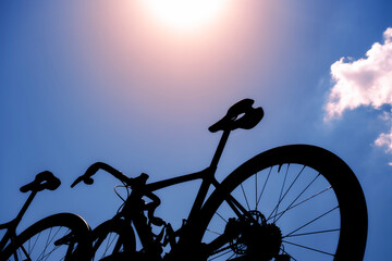 silhouette of a bicycle on the blue sky with bright sun