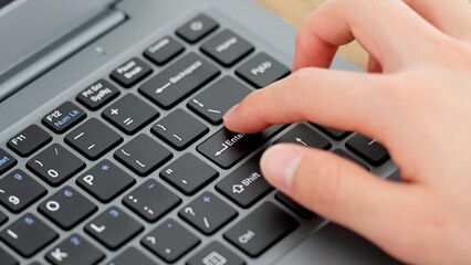 エンターキーを押す男性の手元