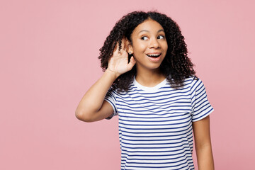 Little curious nosy kid teen girl wears blue striped t-shirt casual clothes try to hear you...