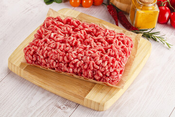 Raw minced beef meat over board