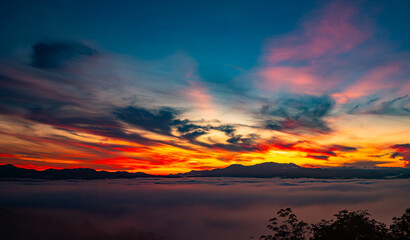 Landscape of majestic clouds in the sky sunset or sunrise over mountains with fog.Beautiful landscape scenery.Amazing light of nature Landscape nature background