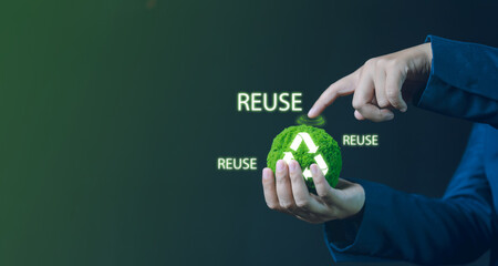 A Hand Holding a Green Replica of a Globe Promoting Recycling, Reusing, and Reducing Waste to Conserve Resources and Protect the Environment for a Sustainable Future