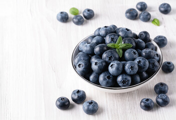 Fresh blueberries on a wooden white table, with copy space for text