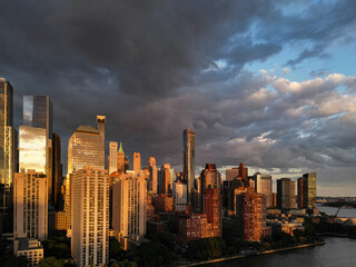 Fototapeta premium New York City top view. NYC aerial view, New York City Skyline with dramatic sky. Panoramic drone view on Manhattan in NY. Sunset in NYC. New York City Midtown skyline view at dusk with clouds.