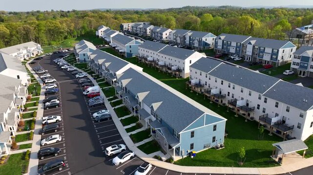 Urban neighborhood in American city suburb at sunny day. Parking cars in front of townhouses.  Aerial flight over similar row of buildings during spring sunset.