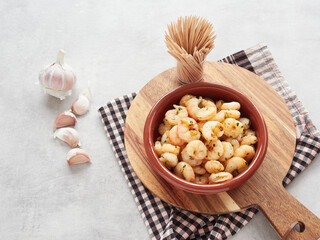 typical spanish tapas: gambas al ajillo (shrimp with garlic), served in an earthenware dish to eat with chopsticks.