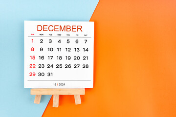 2024 December calendar page on blue and orange background.