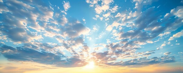 An orange sun on an orange sky with blue skies and clouds