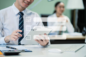 Business performance checklist concept, businessman using tablet and laptop doing online checklist survey, filling out digital form checklist.