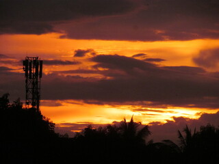 Stunning Orange Sunset Over Silhouetted Trees and Tower