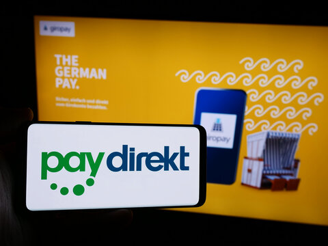 Stuttgart, Germany - 07-04-2024: Person holding smartphone with logo of German payment company Paydirekt GmbH (Giropay) in front of website. Focus on phone display.