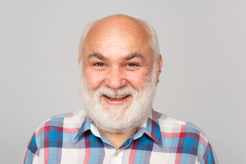 Fototapeta premium Happy old mature man smiling. Closeup portrait of an elegant senior man with grey beard isolated on studio background.