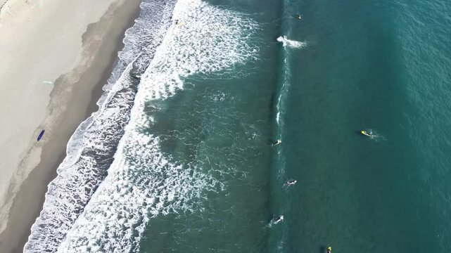 空から見た湘南の波とサーファー