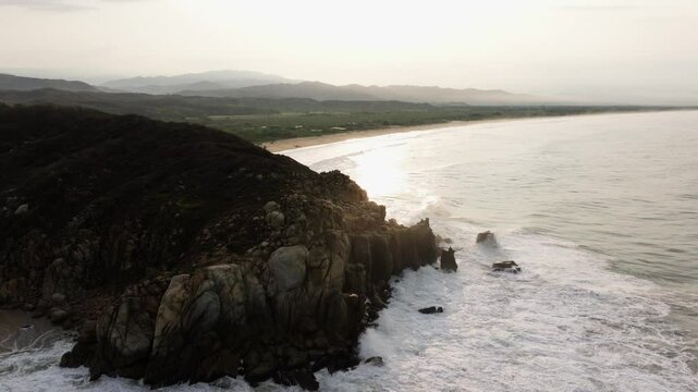 Rocky sea cliff battered by ocean waves with eroded coastal cliffs reveals Puerto Escondido Oaxaca Mexico