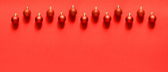 Row of red New Year's balls. Border. Christmas composition with balls. Red background. Top view, flat lay. Empty space for copy space