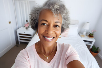 Close up photo of a happy senior African American woman in pastel shirt taking a selfie