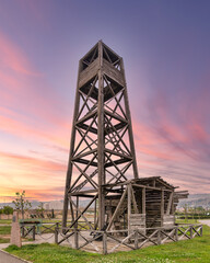 Worlds first industrially drilled oil well in Baku, Azerbaijan. The wooden structure stands tall against a vibrant sunset sky
