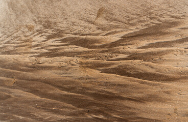 Natural texture: top view of beach sand, clear, clean and smooth. Minimalist background for summer concepts, travel, vacations and outdoor enjoyment.