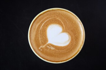 Heart of latte art coffee on black background