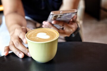 Woman using smart phone on hand and drink coffee cup