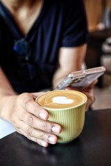 Woman using smart phone on hand and drink coffee cup