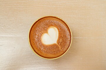 Heart of latte art coffee on wood background