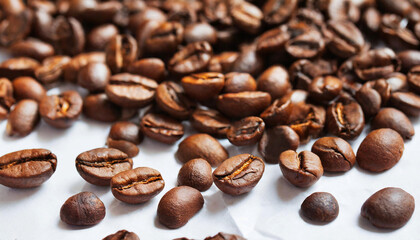 Obraz premium A heap of roasted coffee beans on a white table.