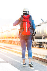 Traveler and tourist asia young women wearing backpack holding map, waiting for a train. Travel Concept.