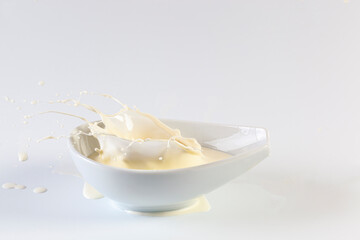 Milk splash in a bowl on white background...