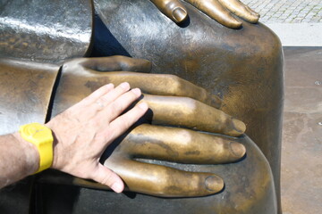 Denkmal für Karl Marx und Friedrich Engels in Berlin - männliche Hand mit gelber Armbanduhr liegt...