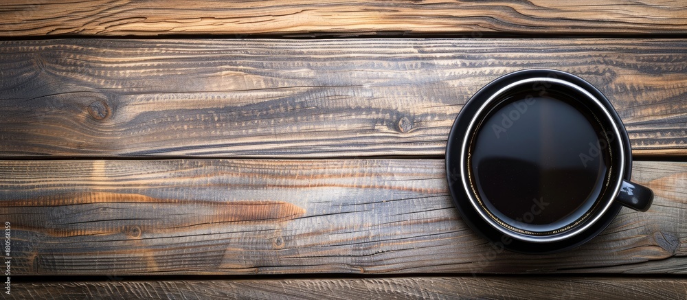 Aufkleber Top view of a black coffee cup on a wooden table with a clear surface available for writing in the background space with no content for adding an inscription. copy space available