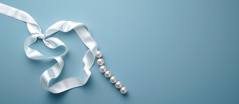 Lung Cancer Awareness symbol alongside Mesothelioma and Retinoblastoma signs shown A white pearl ribbon bow curls on a blue backdrop with a copy space image symbolizing purity and support against viol