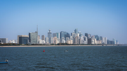 Fototapeta premium Modern City Skyline with Clear Blue Sky and Riverside View
