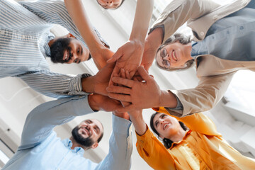 Diverse group of business people joining hands in circle selective focus