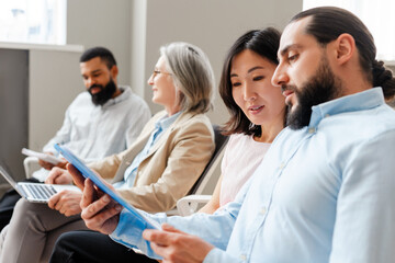 Young diverse business people having meeting and reading documents in modern office