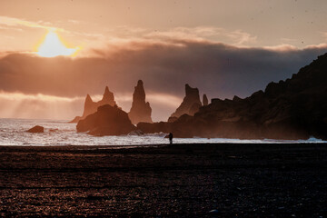 Silhouette of Reynisdrangar sea stacks at sunset on Vík's black sand beach, south coast of Iceland