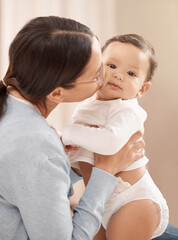 Mom, baby and bonding with kissing at home for care, support and child development or growth. People, parent and toddler or infant for fun, security and trust with comfort for love and relax