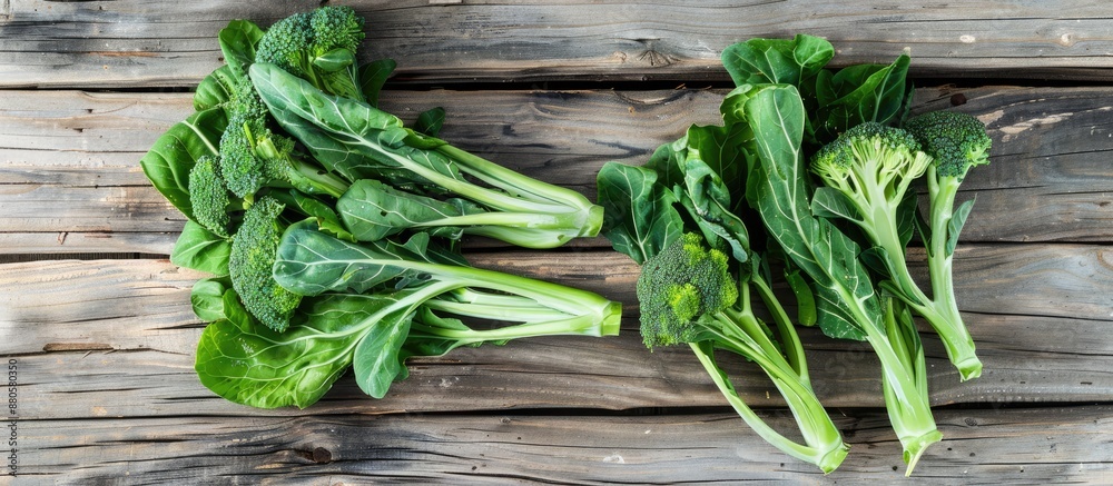 Poster Green fresh Gai lan Chinese broccoli on a wooden plank viewed from the top with a clear background suitable for text or other elements in the copy space image
