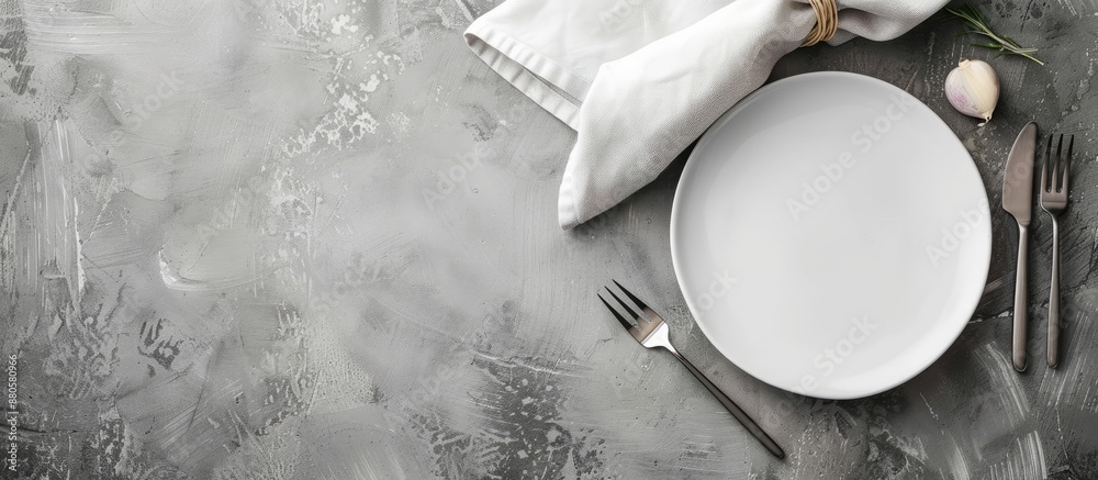Poster Minimalistic gray concept with a ceramic white plate cutlery and a napkin on a gray background ideal for text or image placement. copy space available