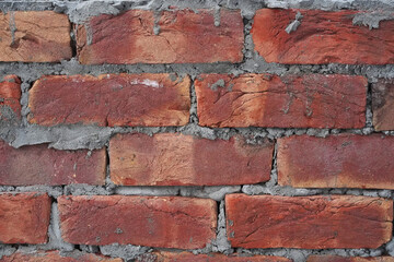 Brick wall, background, cement drips. Backdrop with red brick hand kneaded and moulded. Close-up, detail and texture. Uneven masonry, not neat work, untidy construction. 