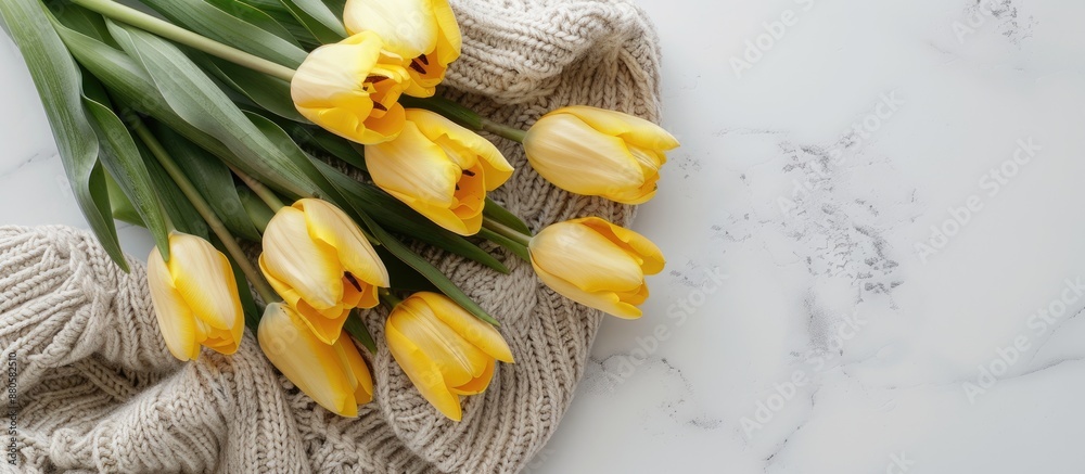 Aufkleber top view of a yellow tulip bouquet on a white background next to a knitted sweater with copy space i