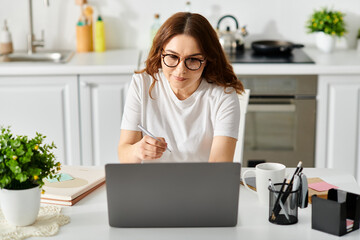 A middle-aged woman engrossed in work on her laptop at a cozy table.