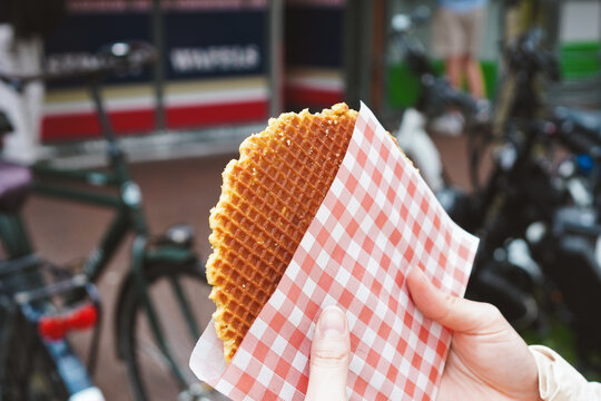 Closeup of girl holding Markus&rsquo; stroopwafels Gouda (Dutch caramel waffle) with both hands
