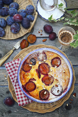Damson blue plum clafoutis (flan) and glass of rose wine, icing sugar and almonds dressing, french cuisine
