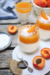 Apricot panna cotta in three glasses, coconut flakes dressing
