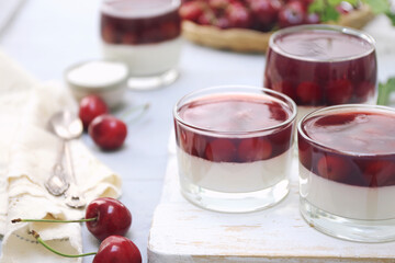 Cherry panna cotta in glasses, coconut flakes dressing and fresh cherry