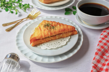 Croque monsieur Ham in white plate  is a delicious french hamand sandwich, on white table with black coffee